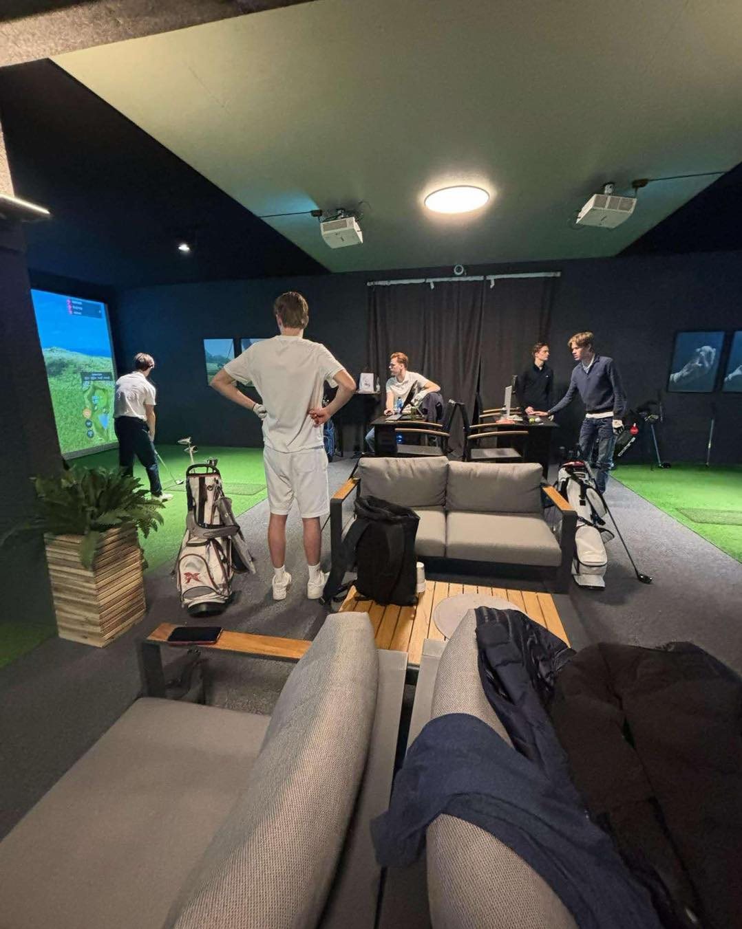 Sofagruppe foran golfsimulatorene hos Moss Padelsenter